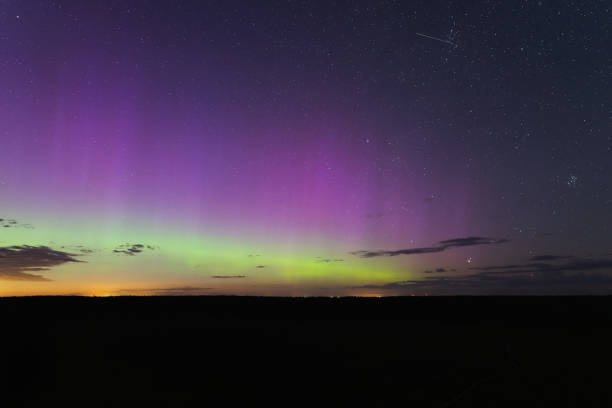 istock Night starry sky, clouds and northern lights. 2166925378