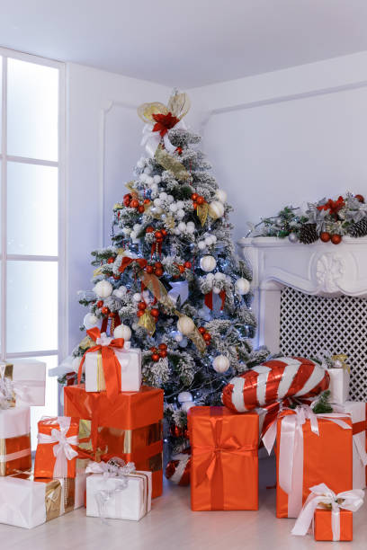 istock colorful Gift boxes with a large red bow against christmas tree. Luxury New Year gift. Christmas presents. Christmastime celebration 2166925506