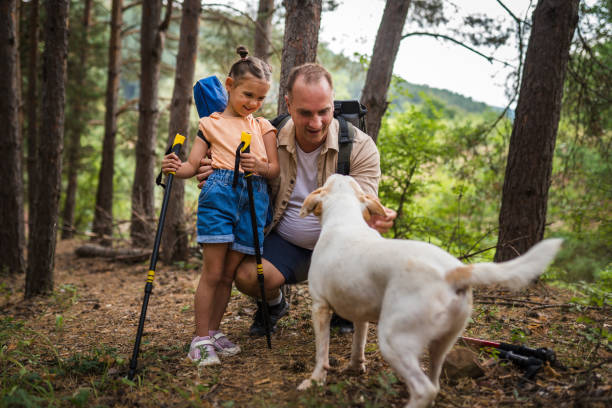 istock Father and daughter playing with a dog in a forest 2166925669