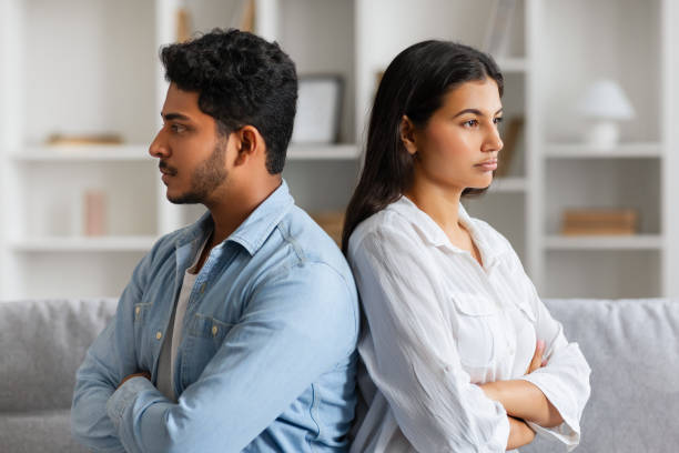 istock Hindu couple sitting back-to-back with troubled expressions 2166926105