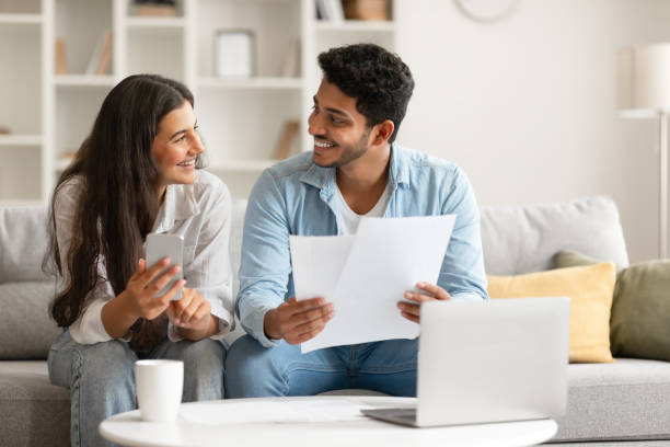 istock Hindu couple planning finances with documents and laptop 2166926133