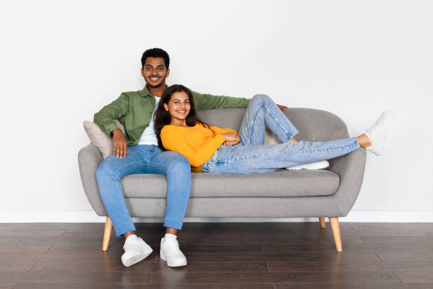 istock Relaxed indian couple lounging on couch and smiling 2166926154