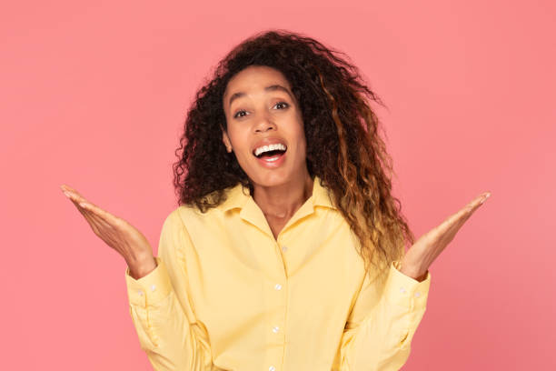 istock Surprised black woman with raised hands on pink background 2166926349