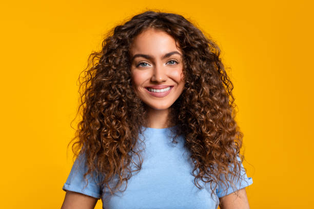 istock Friendly smiling woman with blue shirt on yellow 2166926372