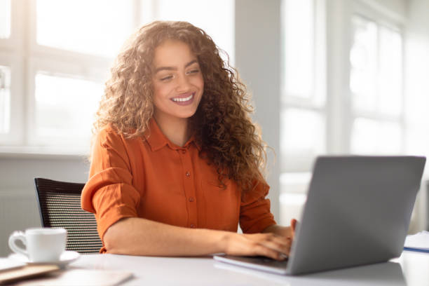 Woman working on laptop with a bright smile