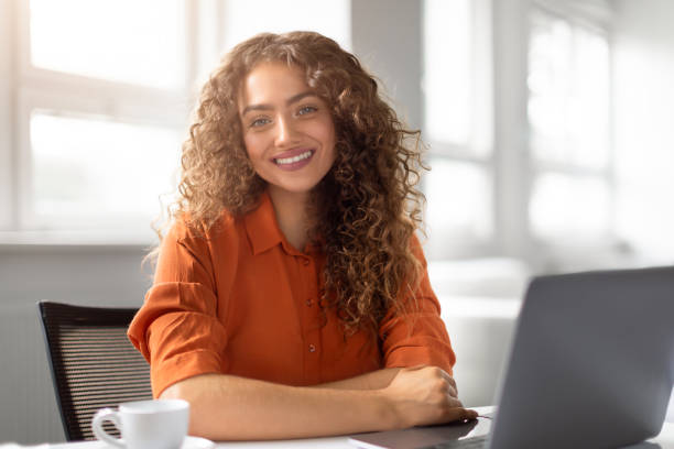 istock Happy young woman posing at her workstation 2166926387