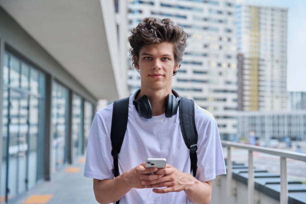 istock Young guy using smartphone, modern skyscrapers urban style background 2166927017