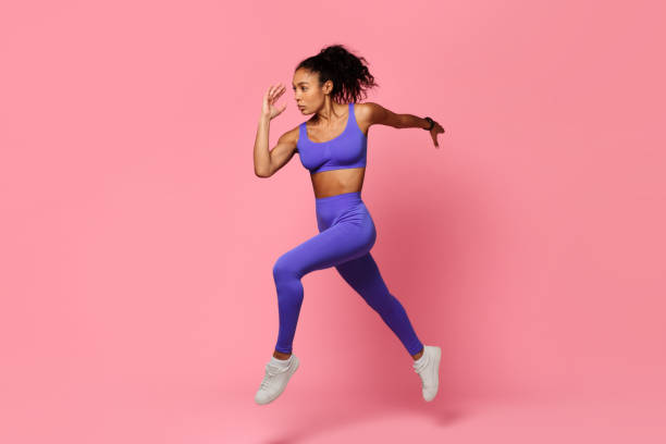 istock Motivated black sportswoman leaps and runs in mid air, studio 2166927588