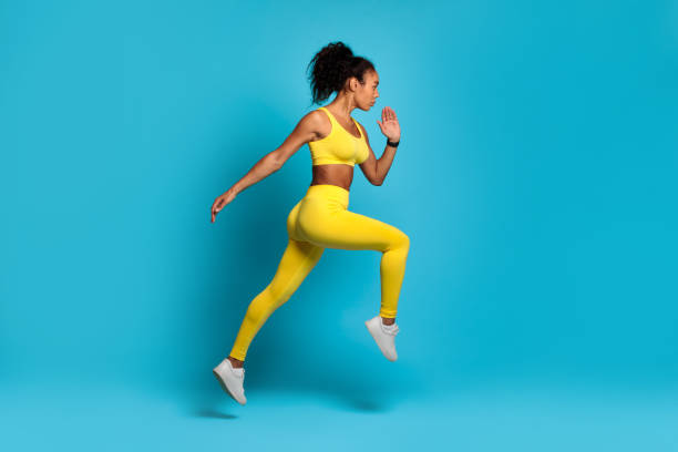 istock Dynamic female athlete running mid-air on blue background 2166927641