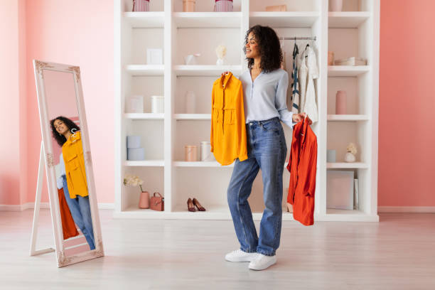 istock Stylish woman choosing between shirts, mirror reflection 2166927679