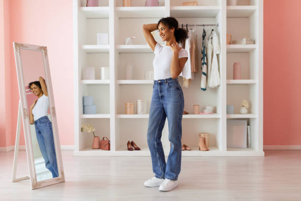 istock Confident latin woman posing in jeans, admiring mirror image 2166927690