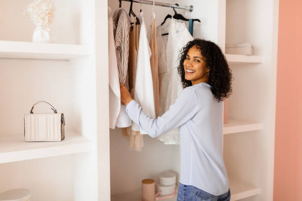 istock Smiling woman selecting clothes from a neat closet 2166927711