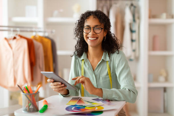 istock Joyful designer with tablet and color wheel in bright studio 2166927713
