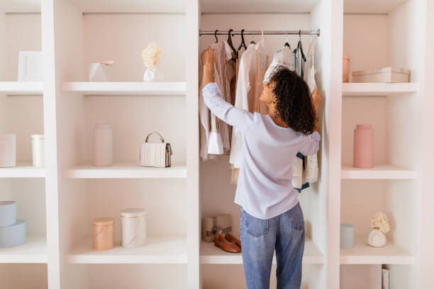 Woman arranging clothes in a chic, open closet