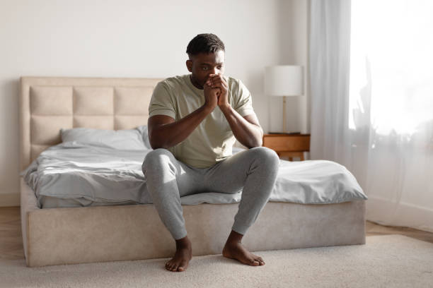 istock Unhappy Black Young Guy Thinking About Loneliness Sitting On Bed 2166928065