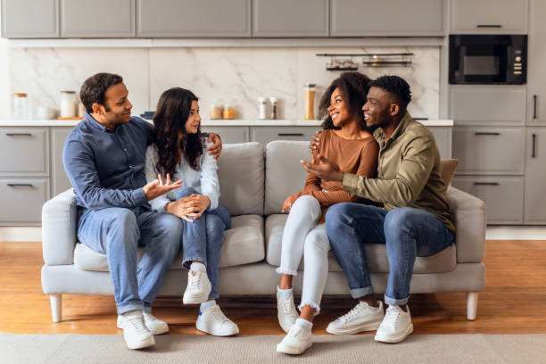 istock Two cheerful diverse couples engaging in lively conversation in kitchen 2166928151