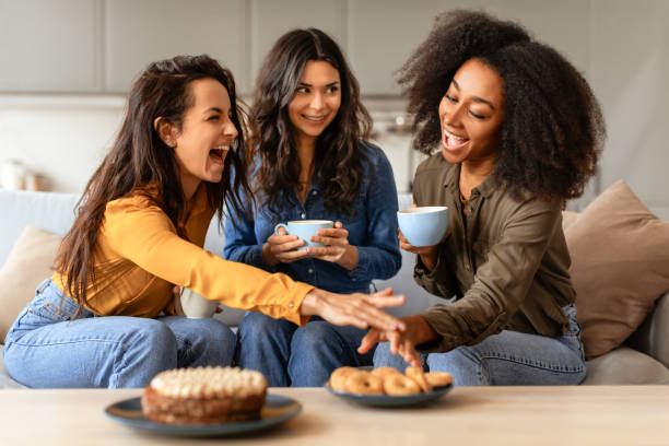 istock Three joyful multiethnic friends ladies share laughter over coffee indoors 2166928176