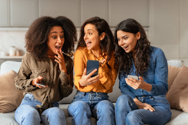 istock Diverse group of three women using cellphone in room indoor 2166928194