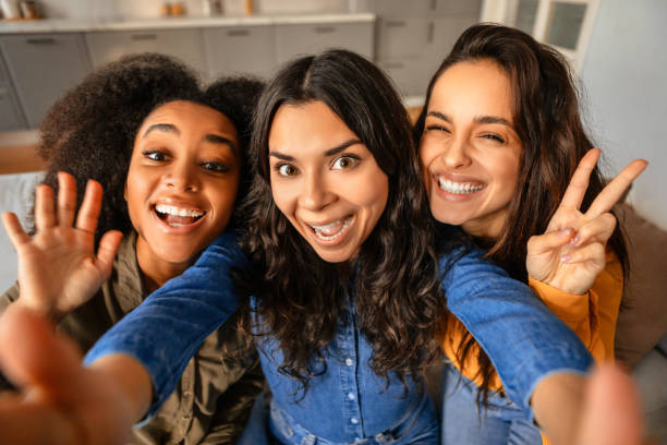 istock Three joyful young multicultural women taking playful selfie at home 2166928197