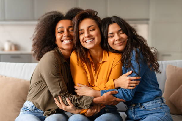 istock Three joyful young multiethnic women hugging and smiling together indoor 2166928211