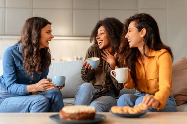 istock Three ladies talking and laughing over coffee and cake indoor 2166928215