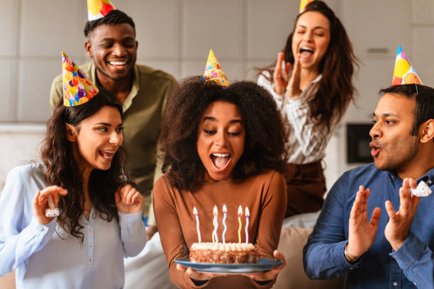 istock Excited friends blowing candles on birthday cake 2166928237