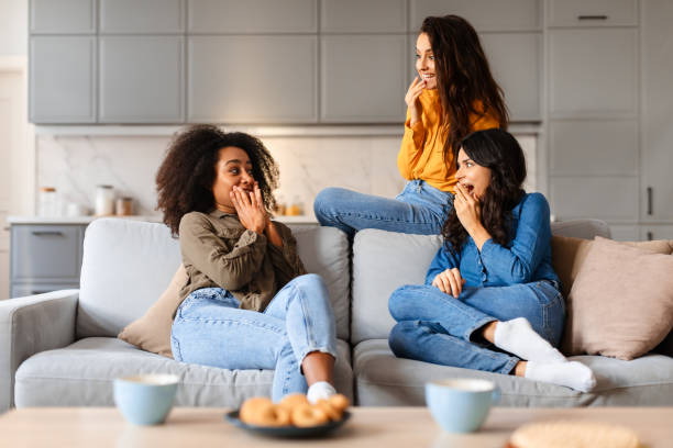 istock Three women laughing on a couch together 2166928253