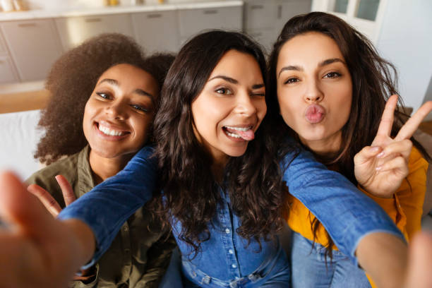 Three friends take a playful selfie together
