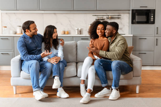istock Two couples smiling and sitting on a couch 2166928275