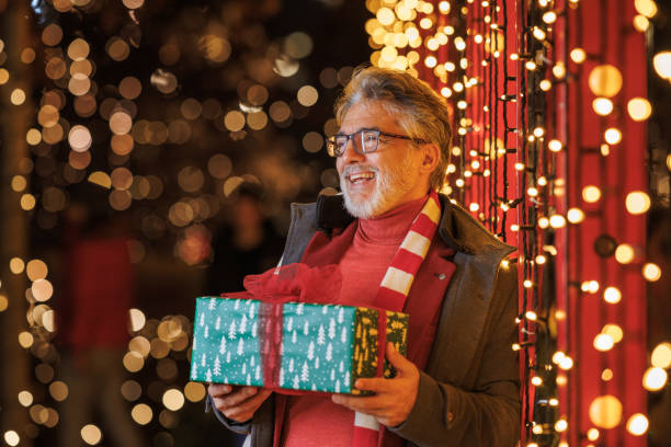 istock Mature man holding a Christmas present 2166928419