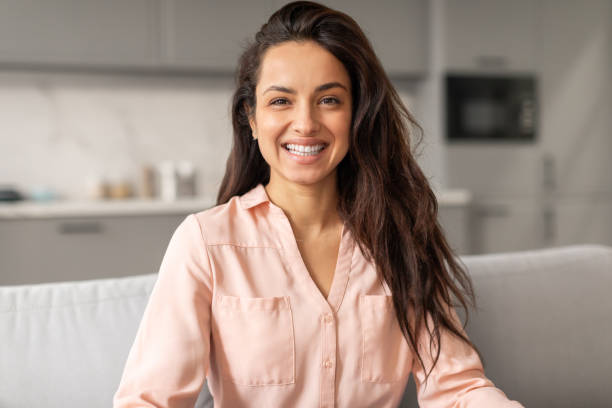 istock Radiant woman with bright smile sitting on sofa 2166928790