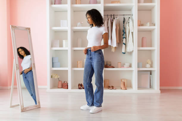 istock Contemplative woman trying on blue jeans 2166928864