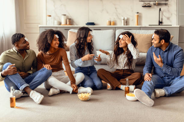 istock Diverse students engaged in fun games playing Guess Who indoor 2166929055