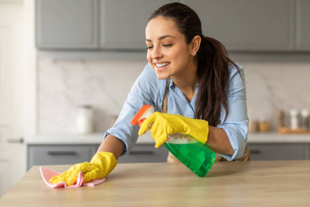 istock Smiling woman cleaning kitchen counter with spray 2166929195
