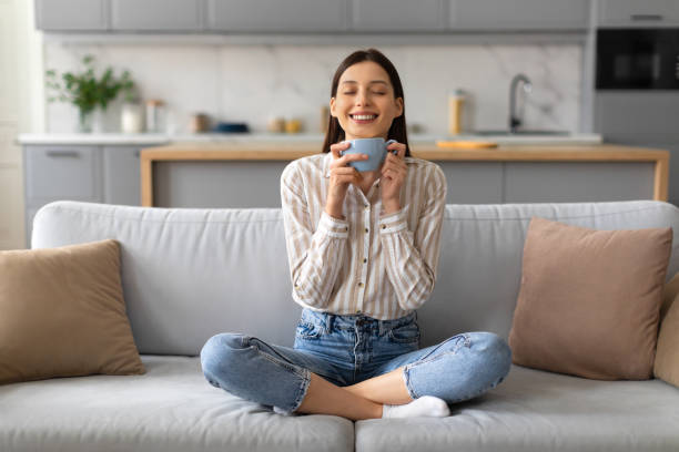 istock Content young woman enjoying coffee on couch 2166929597