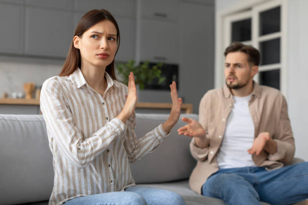 istock Spouses in heated argument at home, sitting on sofa 2166929627