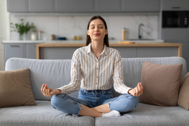 istock Woman practicing meditation on couch at home 2166929661