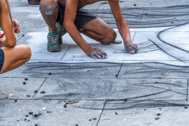 Teenagers participating in the Lake Worth street art festival. They are using chalk to make the drawings.  rr