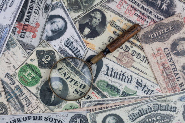 istock US banknotes and silver certificates with silver dollar coins and magnifying glass 2166931191