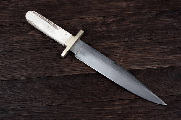 istock Old west bowie knife on wooden deck 2166931351