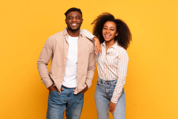 istock Smiling black couple standing together against yellow background 2166932046