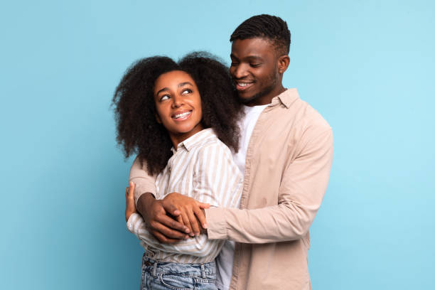 istock Embracing african american couple smiling on blue background 2166932091