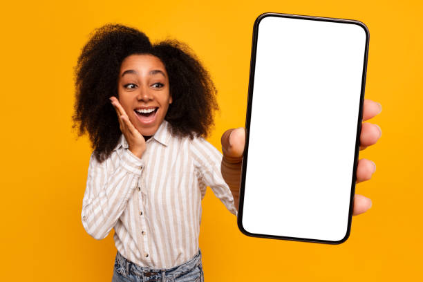 istock Excited woman presenting smartphone screen on yellow 2166932154