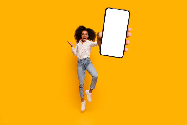 istock Energetic woman jump while holding smartphone with screen 2166932166