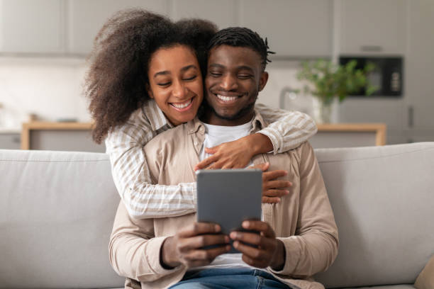 istock Cheerful African American Couple Using Digital Tablet Browsing Internet Indoor 2166932441