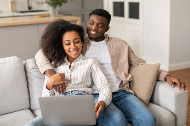istock Happy African American couple using laptop pc watching video indoor 2166932478