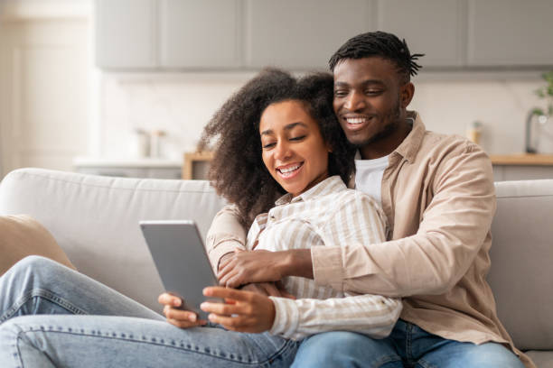istock Happy black young couple exploring content on digital tablet indoor 2166932491