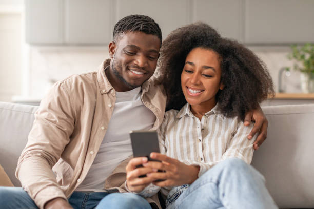 istock Black millennial spouses enjoying leisure time using cellphone at home 2166932525