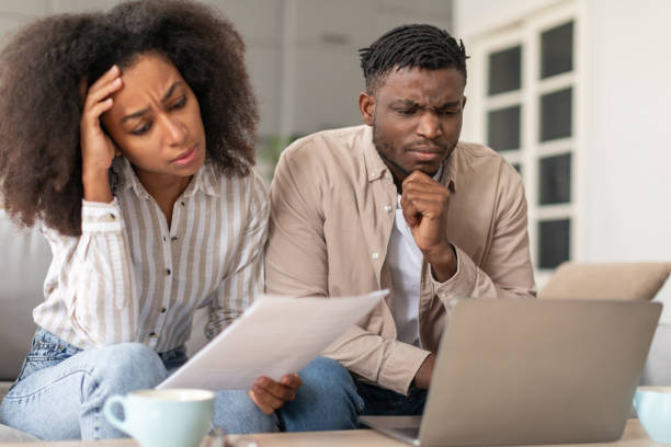 istock Frowning African American married couple using laptop doing paperwork indoor 2166932541