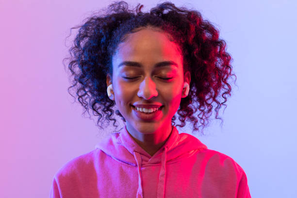 istock Content black lady with earbuds, eyes closed in enjoyment 2166933487